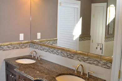 Mid-sized elegant master multicolored tile and matchstick tile light wood floor bathroom photo in New York with an undermount sink, recessed-panel cabinets, dark wood cabinets, granite countertops, a two-piece toilet and brown walls