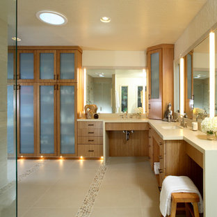 Diseño de cuarto de baño principal, actual, grande, con lavabo bajoencimera, armarios con paneles lisos, puertas de armario de madera oscura, baldosas y/o azulejos beige, suelo de baldosas tipo guijarro, ducha esquinera, baldosas y/o azulejos de piedra y paredes beige