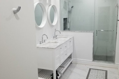 Example of a mid-sized transitional master white tile and porcelain tile porcelain tile and white floor doorless shower design in Toronto with furniture-like cabinets, white cabinets, a one-piece toilet, white walls, an undermount sink, marble countertops, a hinged shower door and white countertops
