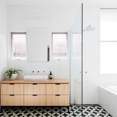 Example of a mid-sized trendy master white tile and porcelain tile mosaic tile floor and multicolored floor bathroom design in Melbourne with light wood cabinets, wood countertops, flat-panel cabinets, white walls and a vessel sink