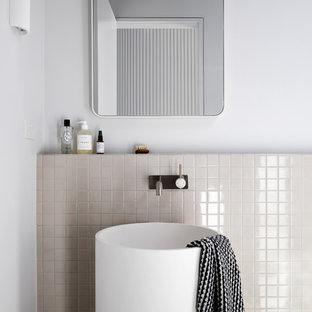 Inspiration for a small contemporary bathroom in Melbourne with a pedestal sink, beige tile, pebble tile and white walls.