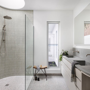 Design ideas for a large contemporary master bathroom in Melbourne with a curbless shower, terrazzo floors, concrete benchtops, an open shower, grey benchtops, flat-panel cabinets, beige cabinets, gray tile, mosaic tile, white walls, an integrated sink and grey floor.