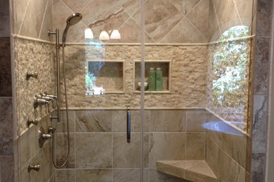 Exemple d'une douche en alcôve principale chic de taille moyenne avec un carrelage beige, un carrelage de pierre, un mur beige, un sol en carrelage de céramique, un sol beige et une cabine de douche à porte battante.