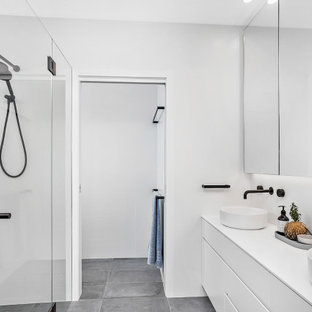 This is an example of a large contemporary 3/4 bathroom in Wollongong with flat-panel cabinets, white cabinets, a curbless shower, white walls, porcelain floors, a vessel sink, grey floor, a hinged shower door, white benchtops, a niche and a floating vanity.