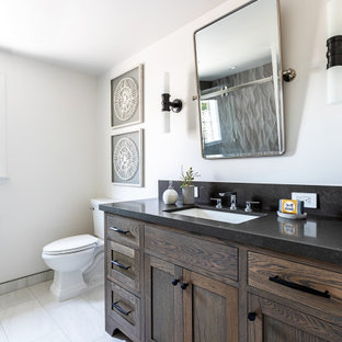Idéer för mellanstora lantliga svart en-suite badrum, med luckor med infälld panel, en toalettstol med hel cisternkåpa, beige väggar, marmorgolv, ett undermonterad handfat, vitt golv, skåp i mörkt trä och granitbänkskiva