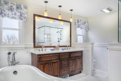 Inspiration for a large contemporary master white tile and ceramic tile ceramic tile and white floor bathroom remodel in New York with raised-panel cabinets, medium tone wood cabinets, a two-piece toilet, yellow walls, a drop-in sink, solid surface countertops and a hinged shower door