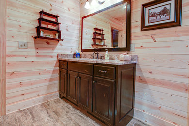 Bathroom - light wood floor bathroom idea in Atlanta with raised-panel cabinets, distressed cabinets, an undermount sink and granite countertops