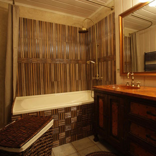 Design ideas for a mid-sized country kids bathroom in Moscow with a pedestal sink, raised-panel cabinets, brown cabinets, copper benchtops, a drop-in tub, a wall-mount toilet, multi-coloured tile, stone tile, beige walls and ceramic floors.