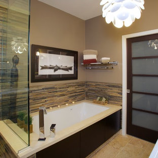 Photo of a large asian master bathroom in Chicago with flat-panel cabinets, dark wood cabinets, multi-coloured tile, an undermount tub, a corner shower, a one-piece toilet, matchstick tile, beige walls, travertine floors, a vessel sink and solid surface benchtops.