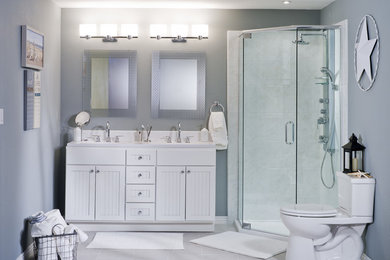 Example of a mid-sized trendy stone tile ceramic tile and gray floor corner shower design in Miami with louvered cabinets, white cabinets, a two-piece toilet, gray walls, an undermount sink, solid surface countertops and a hinged shower door