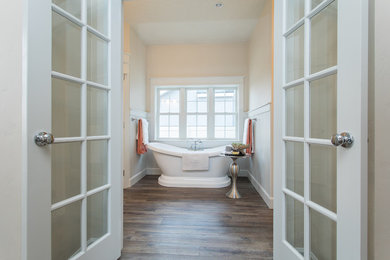Exempel på ett mellanstort klassiskt brun brunt en-suite badrum, med luckor med infälld panel, vita skåp, ett fristående badkar, en dusch i en alkov, en toalettstol med separat cisternkåpa, beige väggar, mellanmörkt trägolv, ett nedsänkt handfat, granitbänkskiva, brunt golv och dusch med skjutdörr