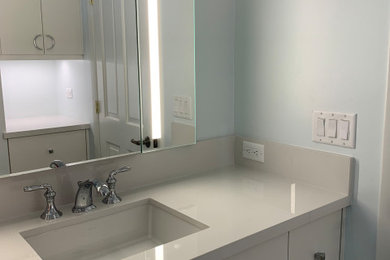 Inspiration for a small transitional kids' white tile and porcelain tile porcelain tile alcove shower remodel in Miami with flat-panel cabinets, white cabinets, a one-piece toilet, white walls, an undermount sink, quartz countertops, a hinged shower door and white countertops