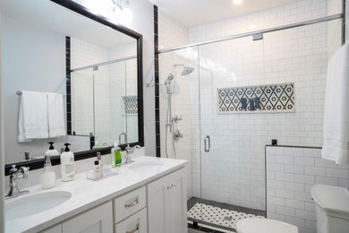Mid-sized cottage white tile and subway tile porcelain tile and white floor bathroom photo in Other with shaker cabinets, white cabinets, a two-piece toilet, gray walls, an undermount sink, quartz countertops, a hinged shower door and white countertops