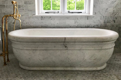 タンパにある中くらいなおしゃれなマスターバスルーム (置き型浴槽、ベージュのタイル、ベージュの壁、大理石の床、ベッセル式洗面器、グレーの床) の写真