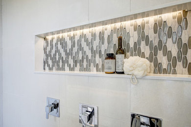 Inspiration for a large modern master white tile and ceramic tile porcelain tile and white floor bathroom remodel in DC Metro with shaker cabinets, brown cabinets, a two-piece toilet, gray walls, an undermount sink, quartz countertops, a hinged shower door and white countertops