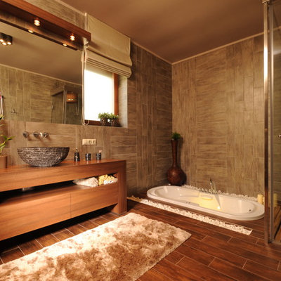 Example of a trendy brown tile bathroom design with a vessel sink and medium tone wood cabinets