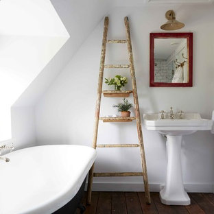 Small rural ensuite bathroom in London with a freestanding bath, white walls, dark hardwood flooring, brown floors and a pedestal sink.