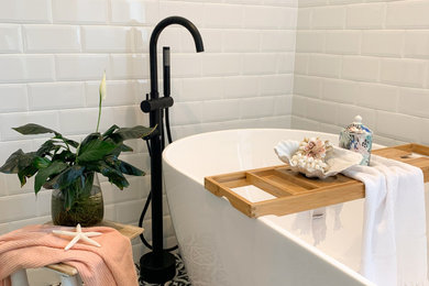 Modern inredning av ett vit vitt en-suite badrum, med vita skåp, ett fristående badkar, en öppen dusch, vit kakel, vita väggar, klinkergolv i keramik, marmorbänkskiva, flerfärgat golv och med dusch som är öppen