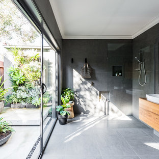 Ispirazione per una stanza da bagno design con ante in legno scuro, doccia alcova, piastrelle grigie, pareti grigie, lavabo a bacinella, top in legno, pavimento grigio, doccia aperta e top marrone