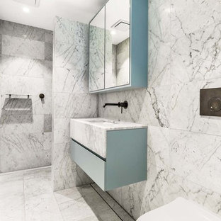 Photo of a mid-sized contemporary master bathroom in Sydney with blue cabinets, a wall-mount toilet, gray tile, white tile, marble, grey walls, marble floors, an undermount sink, marble benchtops, grey floor, an open shower, flat-panel cabinets, a curbless shower and white benchtops.