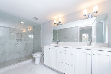 Alcove shower - large contemporary master gray tile and marble tile marble floor and gray floor alcove shower idea in Charleston with shaker cabinets, white cabinets, a two-piece toilet, gray walls, an undermount sink and a hinged shower door