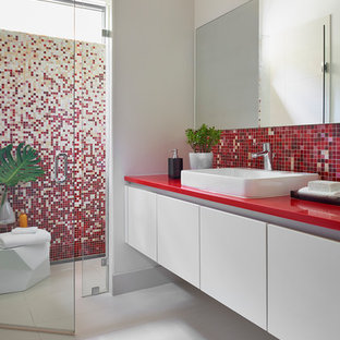 Inspiration for a mid-sized contemporary 3/4 bathroom in Atlanta with flat-panel cabinets, white cabinets, a curbless shower, multi-coloured tile, mosaic tile, white walls, porcelain floors, a vessel sink, engineered quartz benchtops, grey floor, a hinged shower door, a one-piece toilet and red benchtops.