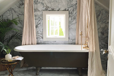 На фото: ванная комната среднего размера в стиле неоклассика (современная классика) с ванной на ножках, душем над ванной, биде, разноцветной плиткой, мраморной плиткой, бежевыми стенами, мраморным полом, консольной раковиной, мраморной столешницей, шторкой для ванной, тумбой под одну раковину и панелями на стенах с