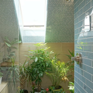 Foto di una stanza da bagno padronale scandinava di medie dimensioni con lavabo integrato, ante lisce, ante in legno chiaro, top in legno, vasca freestanding, doccia aperta, WC monopezzo, piastrelle blu, piastrelle di vetro, pareti bianche e pavimento con piastrelle in ceramica