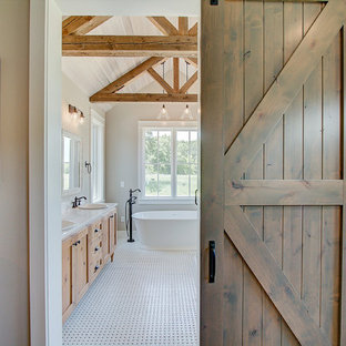 Large country master bathroom in Milwaukee with flat-panel cabinets, light wood cabinets, a freestanding tub, an open shower, a one-piece toilet, beige tile, wood-look tile, beige walls, ceramic floors, a drop-in sink, granite benchtops, beige floor, white benchtops, a double vanity, a freestanding vanity and timber.