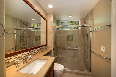 Small elegant 3/4 multicolored tile and porcelain tile porcelain tile alcove shower photo in Orange County with raised-panel cabinets, medium tone wood cabinets, a one-piece toilet, beige walls, an undermount sink and quartz countertops