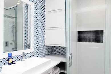 Inspiration for a small traditional shower room bathroom in Montreal with a vessel sink, flat-panel cabinets, white cabinets, multi-coloured tiles, engineered stone worktops, a corner shower, a one-piece toilet, porcelain tiles and porcelain flooring.