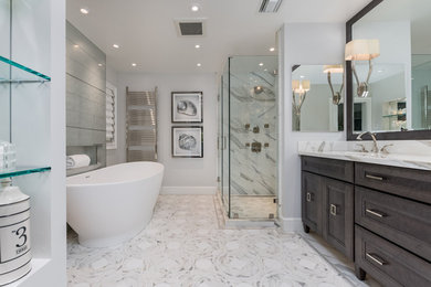 Large transitional master white tile and marble tile marble floor and white floor bathroom photo in New York with furniture-like cabinets, dark wood cabinets, a two-piece toilet, gray walls, an undermount sink, marble countertops, a hinged shower door and white countertops
