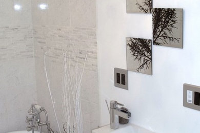 Modelo de cuarto de baño actual pequeño con armarios con paneles lisos, puertas de armario blancas, bañera exenta, paredes blancas, aseo y ducha y lavabo integrado