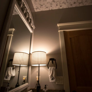 Small country 3/4 dark wood floor, brown floor, single-sink and wallpaper ceiling bathroom photo in Grand Rapids with furniture-like cabinets, brown cabinets, a one-piece toilet, beige walls, an undermount sink, granite countertops, black countertops and a built-in vanity