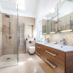 Inspiration for a contemporary shower room bathroom in London with flat-panel cabinets, dark wood cabinets, a corner shower, a wall mounted toilet, beige tiles, beige walls, an integrated sink, beige floors and white worktops.