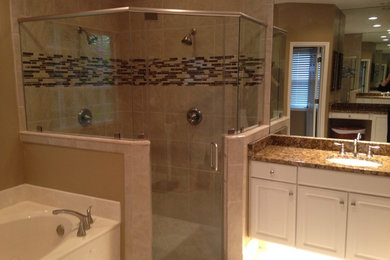 Example of a large classic beige tile and porcelain tile porcelain tile bathroom design in Jacksonville with flat-panel cabinets, granite countertops, a two-piece toilet and an undermount sink