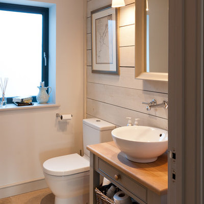 Small beach style ceramic tile and beige floor bathroom photo in Devon with a vessel sink, gray cabinets, white walls, shaker cabinets, a two-piece toilet, wood countertops and gray countertops