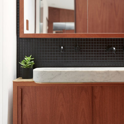 Small minimalist master black tile and ceramic tile concrete floor and gray floor bathroom photo in San Francisco with flat-panel cabinets, medium tone wood cabinets, a wall-mount toilet, black walls and a pedestal sink