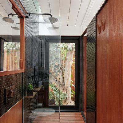 Small trendy master black tile and ceramic tile bathroom photo in San Francisco with flat-panel cabinets, medium tone wood cabinets, a wall-mount toilet, black walls and a wall-mount sink