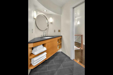 シアトルにあるお手頃価格の中くらいなトラディショナルスタイルのおしゃれなマスターバスルーム (アンダーカウンター洗面器、フラットパネル扉のキャビネット、中間色木目調キャビネット、一体型トイレ	、黒いタイル、白い壁、セラミックタイルの床) の写真