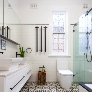 Mid-sized contemporary bathroom in Sydney with shaker cabinets, white cabinets, a corner tub, a corner shower, a one-piece toilet, white tile, porcelain tile, white walls, porcelain floors, black floor, a sliding shower screen, grey benchtops, a niche, a double vanity and a built-in vanity.