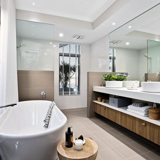 Large contemporary master bathroom in Perth with a freestanding tub, an alcove shower, beige walls, ceramic floors, a vessel sink, brown floor, an open shower, white benchtops, open cabinets, medium wood cabinets and brown tile.