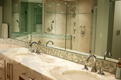 Example of a mid-sized beach style master beige tile and ceramic tile ceramic tile and beige floor bathroom design in Miami with shaker cabinets, medium tone wood cabinets, a one-piece toilet, beige walls, an undermount sink, quartzite countertops and a hinged shower door