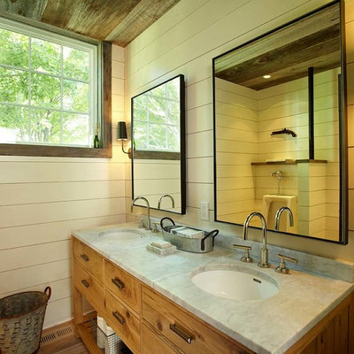 Farmhouse bathroom photo in New York with an undermount sink, furniture-like cabinets and medium tone wood cabinets