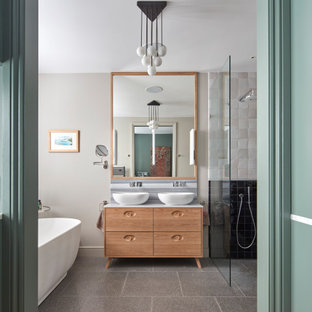 This is an example of a large contemporary ensuite bathroom in London with freestanding cabinets, light wood cabinets, a freestanding bath, a walk-in shower, black and white tiles, cement tiles, terrazzo flooring, a vessel sink, marble worktops, an open shower, multi-coloured worktops, grey walls and grey floors.