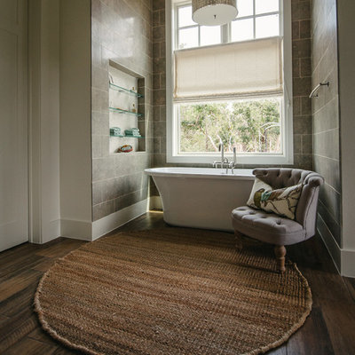 Example of a transitional limestone tile freestanding bathtub design in Austin with a niche