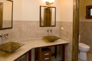 Inspiration för amerikanska en-suite badrum, med ett fristående handfat, möbel-liknande, skåp i mörkt trä, bänkskiva i kalksten, beige kakel, porslinskakel, beige väggar och klinkergolv i porslin