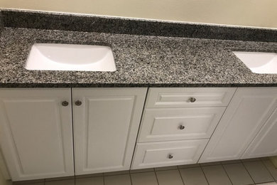 Mid-sized beach style master bathroom photo in Tampa with raised-panel cabinets, white cabinets, beige walls, an undermount sink, granite countertops and gray countertops