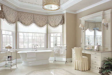 Freestanding bathtub - large traditional master limestone floor and white floor freestanding bathtub idea in New York with recessed-panel cabinets, white cabinets, granite countertops, beige walls and an undermount sink