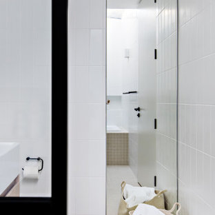 Réalisation d'une petit salle de bain principale design avec des portes de placard marrons, un bain japonais, un espace douche bain, un WC à poser, un carrelage blanc, des carreaux de céramique, un mur blanc, un sol en carrelage de céramique, un lavabo suspendu, un sol beige et aucune cabine.